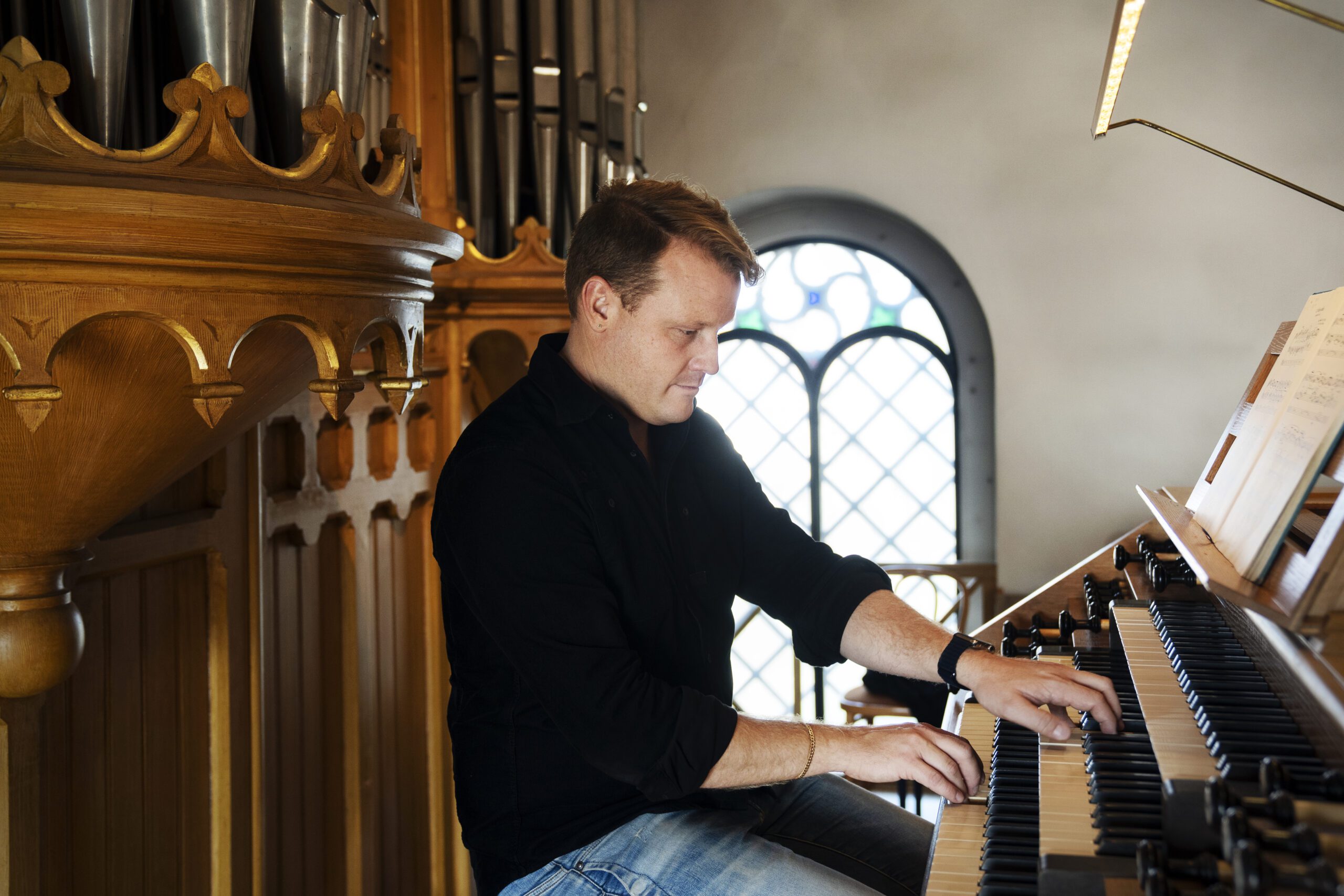 Kompositören och kantorn jens bragdell eriksson intervjuas i Husie kyrka.