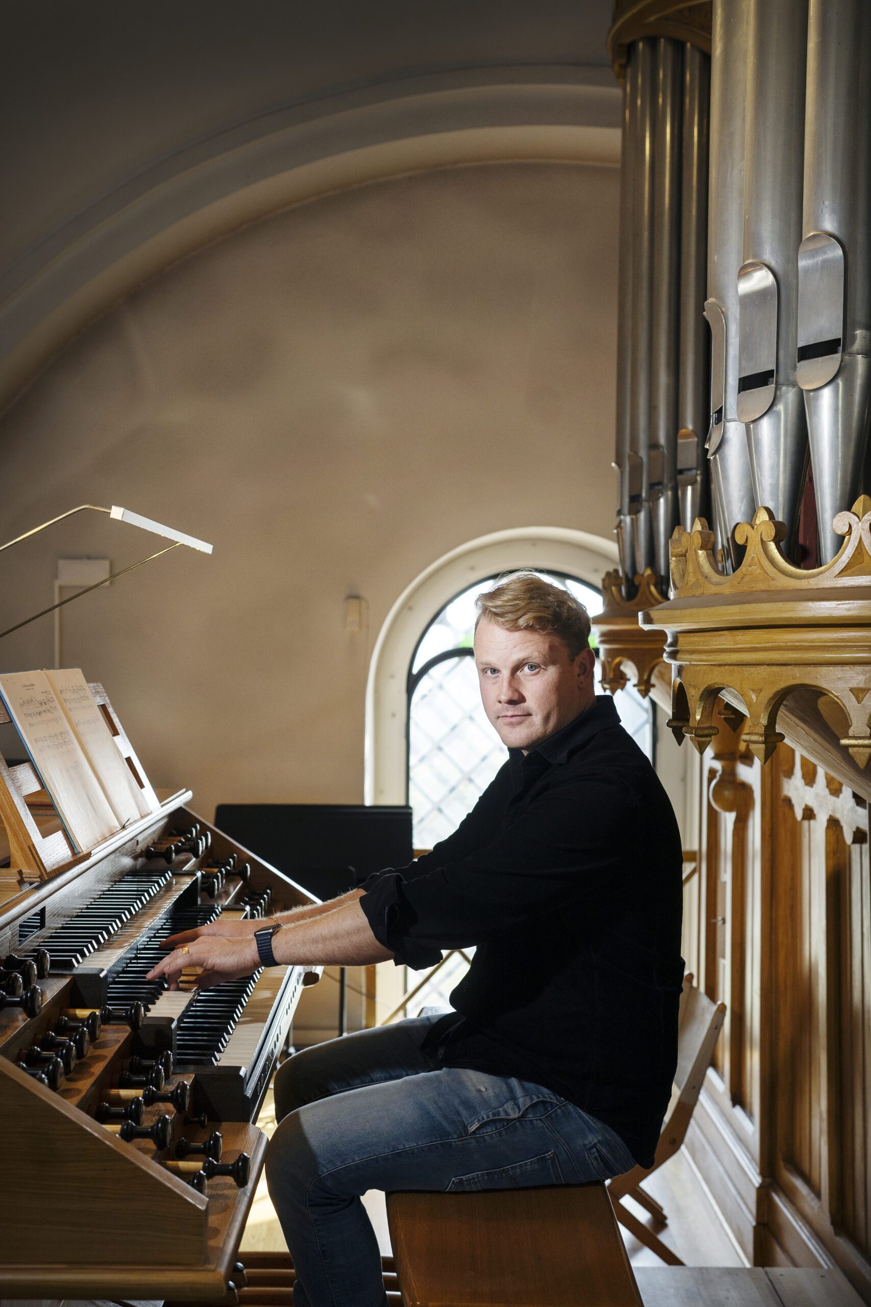Kompositören och kantorn Jens Bragdell Eriksson spelar orgel i Husie kyrka.